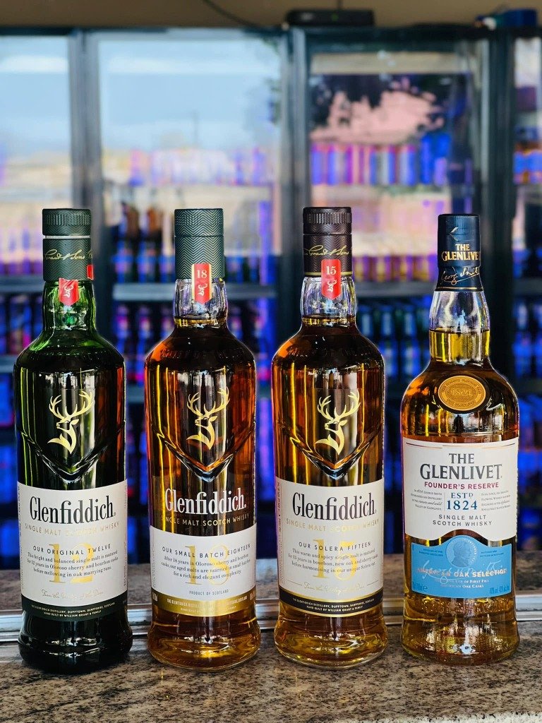 Premium Glenfiddich and Glenlivet Whisky Bottles on Bar Counter